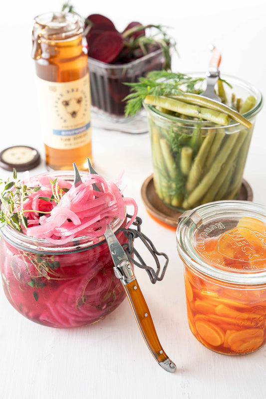 Jars of honey pickled red onion, radishes, beans and beets. 