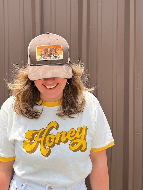 Savannah Bee Employee modeling the Bee Box trucker hat.