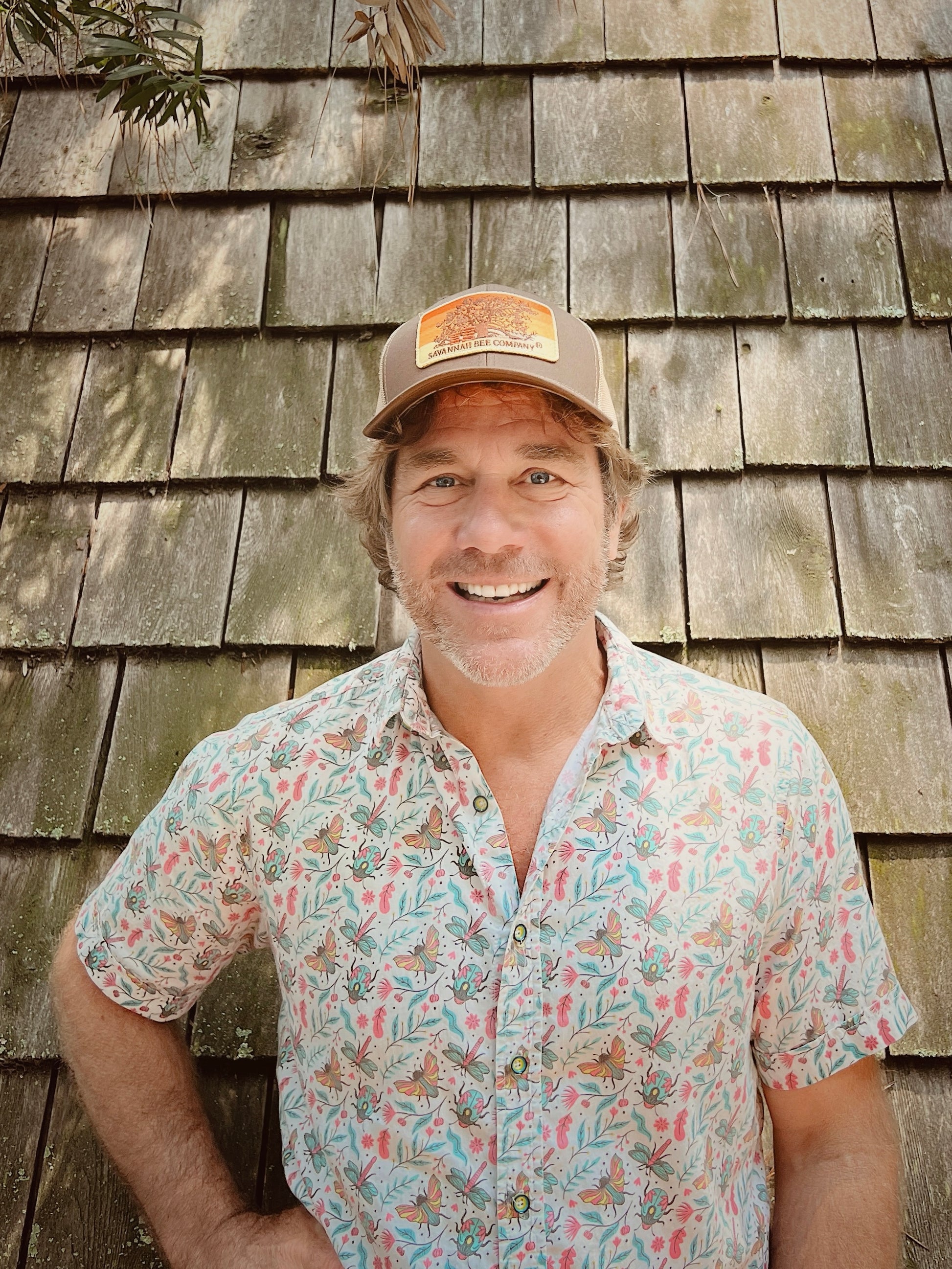 Owner Ted Dennard outside the Bee Therapy Hut modeling the Bee Box Trucker Hat.