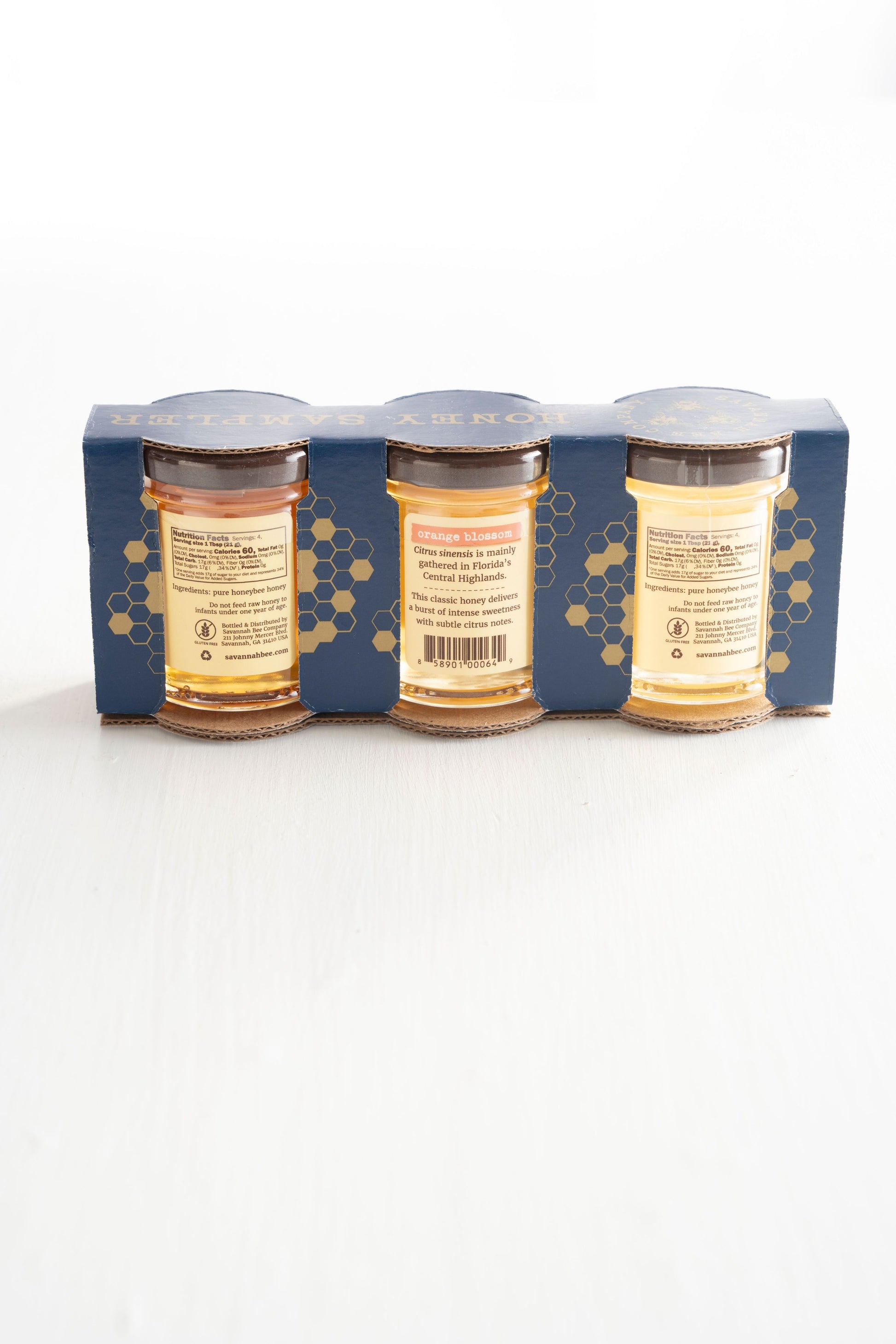 Pure & Natural Acacia 3 oz. mini, Orange Blossom 3 oz. mini and Lavender 3 oz. mini Raw Honey gift in blue packaging with gold honeycomb print.