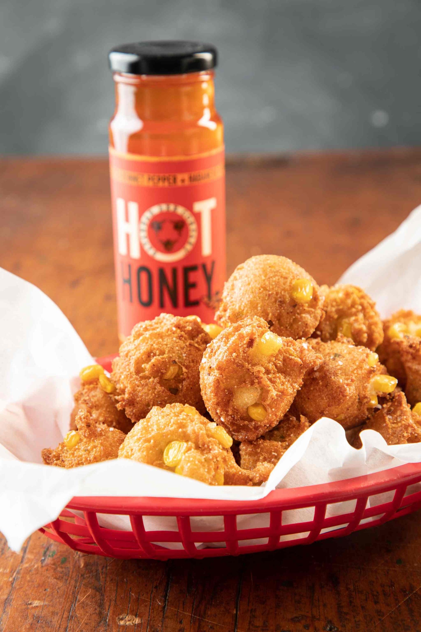 12 ounce hot honey jar with a basket of fried corn balls