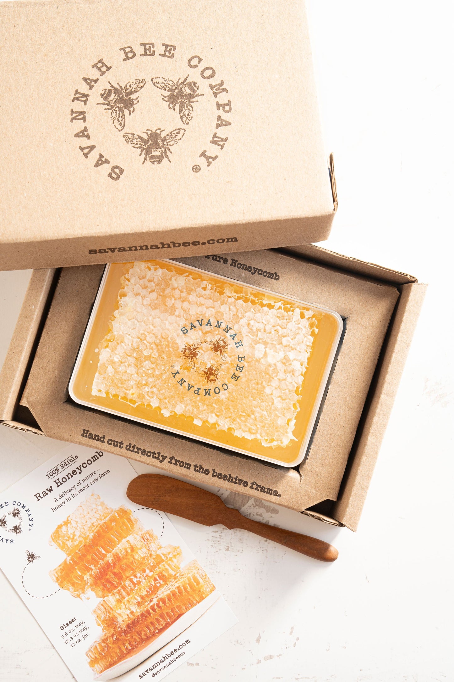 Large honeycomb in a gift box with a teak spoon and an info card.
