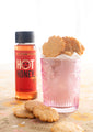 Hot honey squeeze bottle next to a cup full of hot honey biscuits.