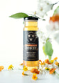 12 ounce Port Bourbon Barrel Aged Orange Blossom Honey  surrounded by orange blossoms against a white background.