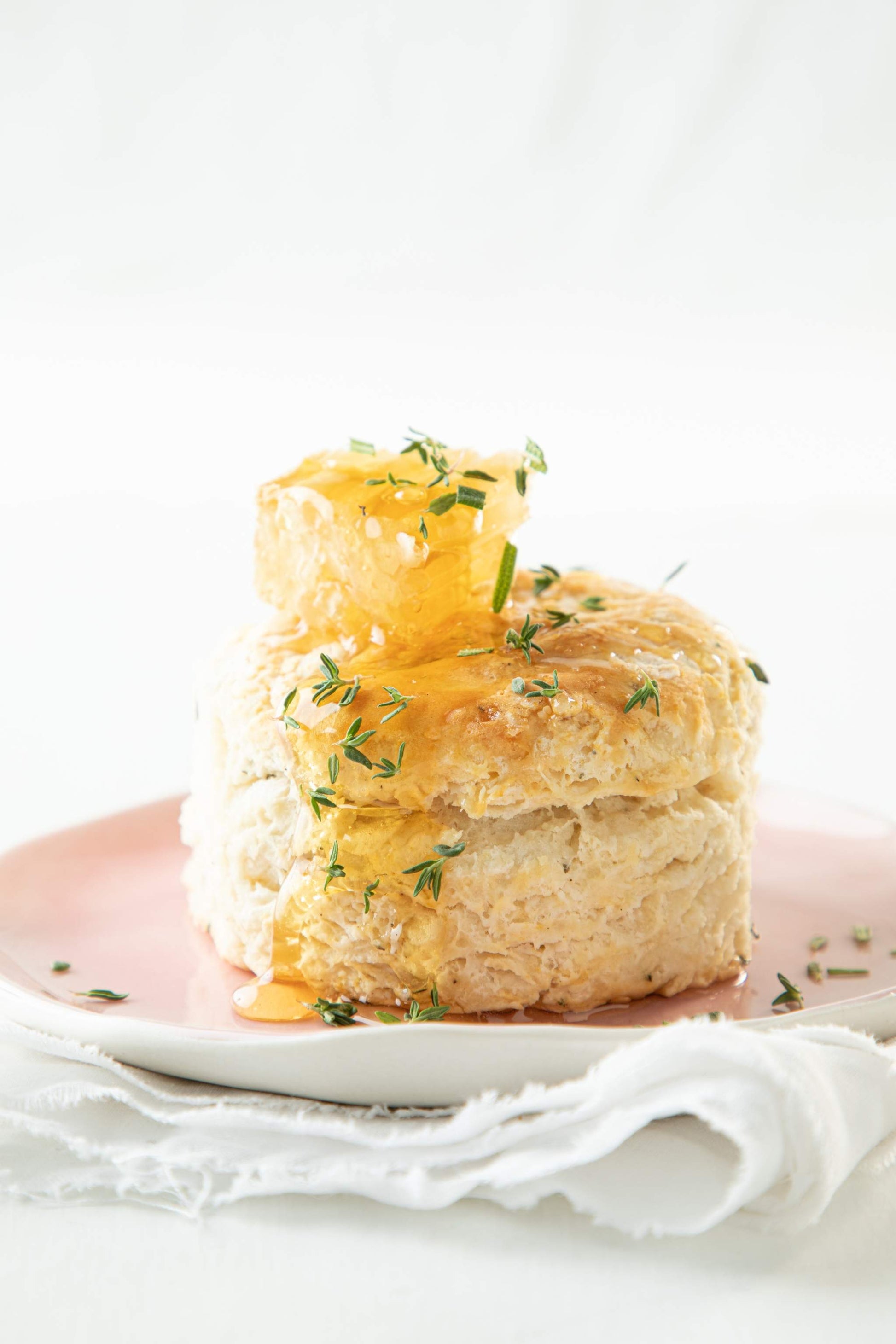 A fluffy biscuit, plated with a sprinkle of rosemary and Acacia Honeycomb on top.
