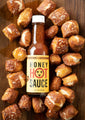 Honey hot sauce surrounded by pretzel bites on a table