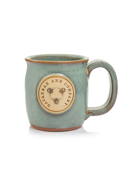 Handcrafted stoneware mug in light blue color with Savannah Bee Company logo on the front