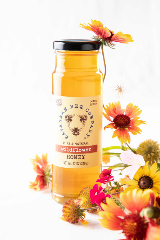 Pure & Natural Wildflower Honey 12 oz. tower with wildflower bouquet.