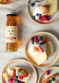 12 ounce wildflower honey with 5 plates of pound cake with whipped cream and berries.
