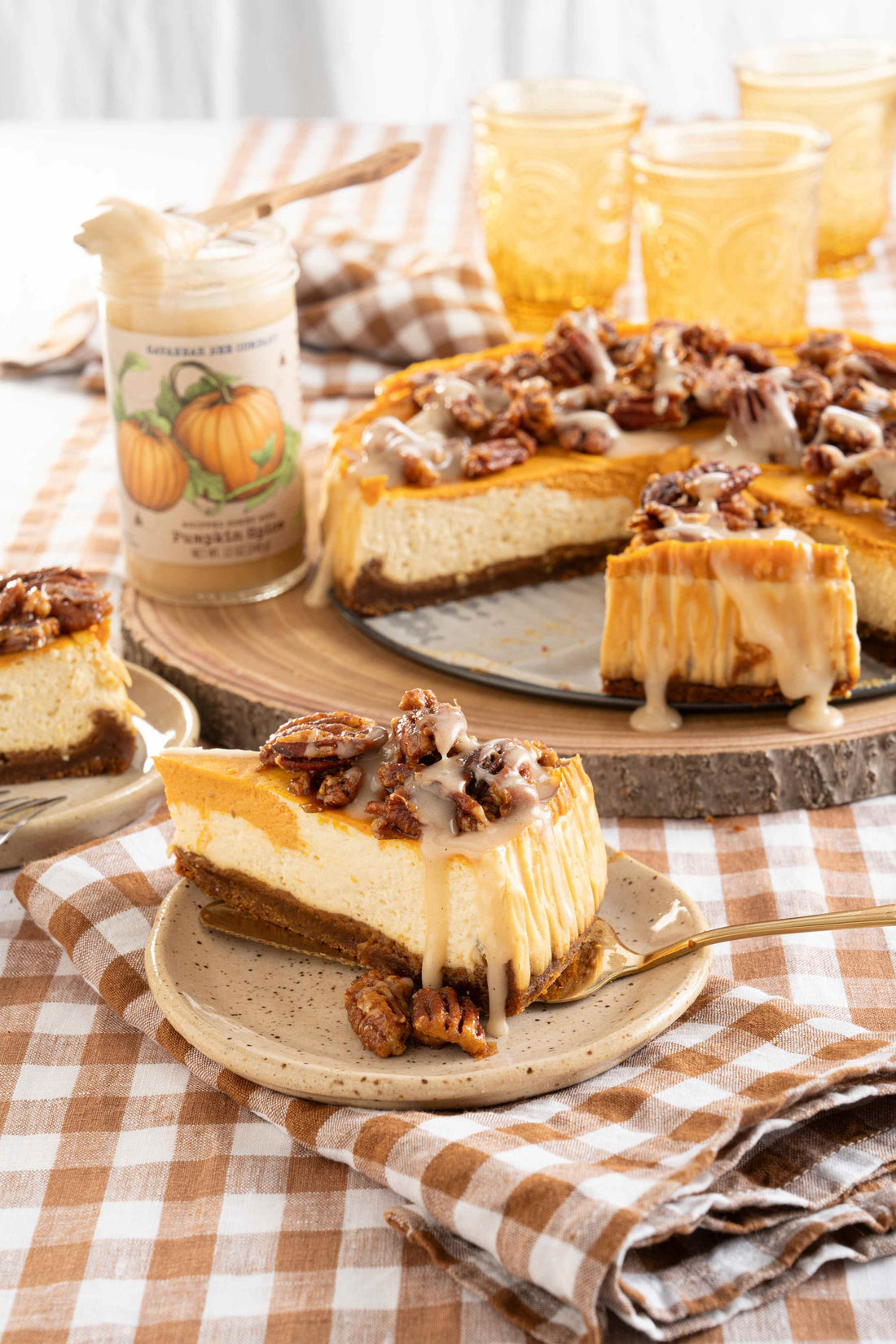 Pumpkin spice praline cheesecake drizzled with pumpkin spice honey on a picnic table cloth.