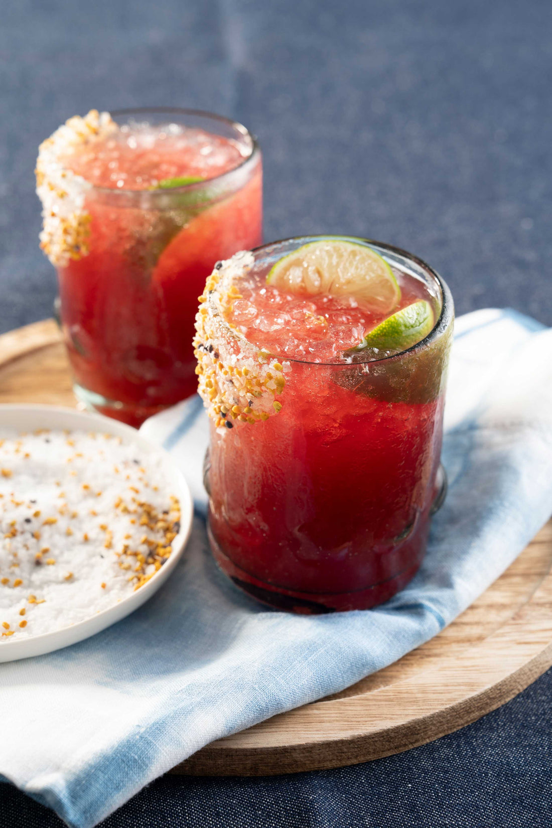 Red margaritas with lime garnish.