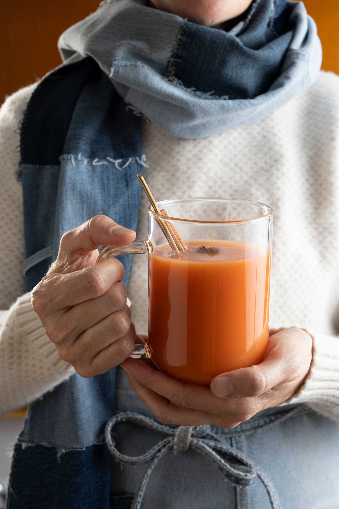 Blood orange hot toddy held by a lady in denim. 