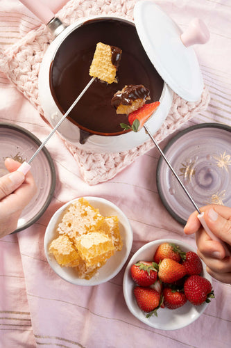 Chocolate fondue with honeycomb and strawberries.