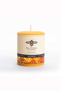 Beeswax candle with a visible brand label on a white background