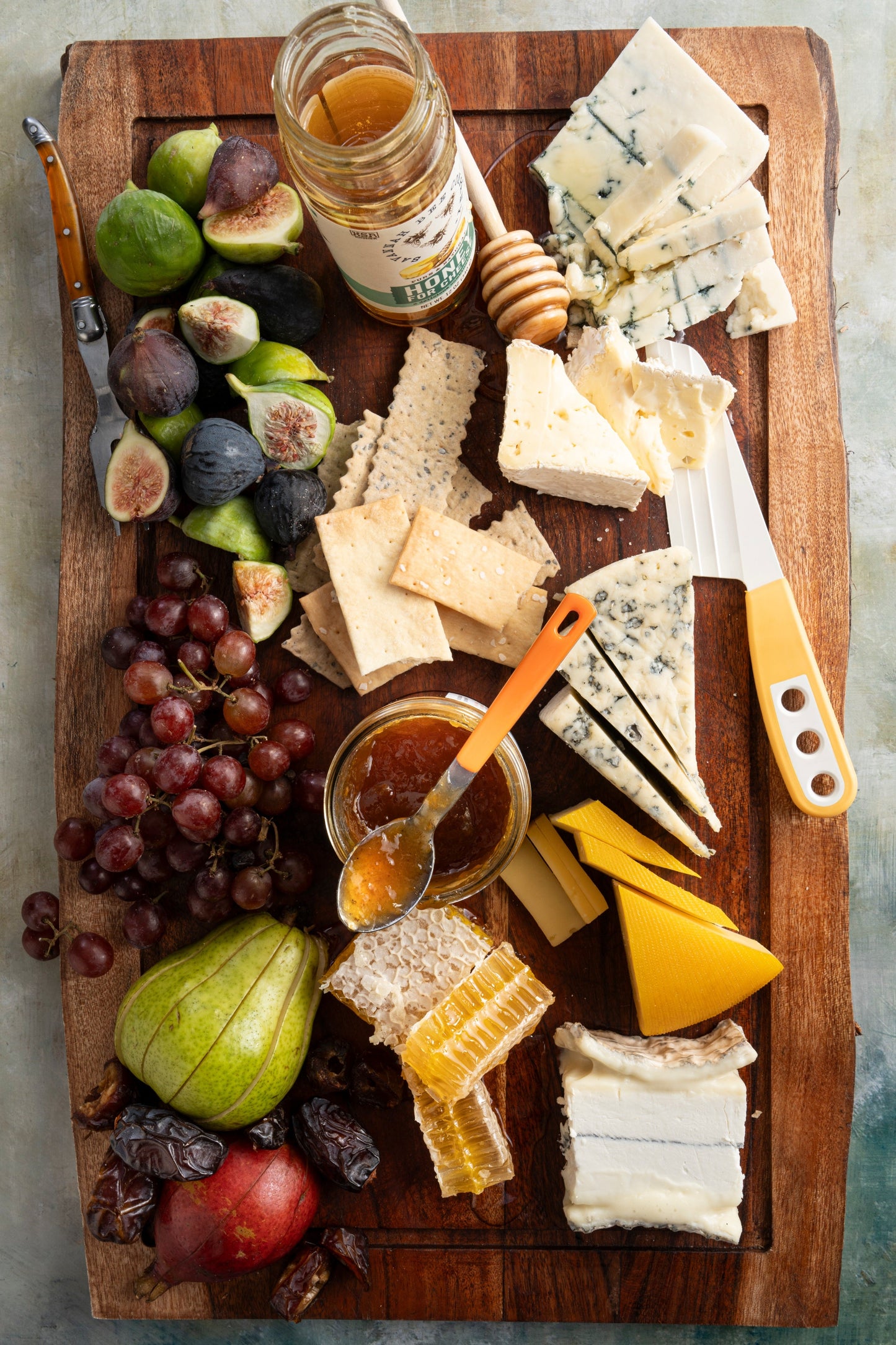 A fruit and cheese platter with a 12 ounce honey for cheese jar and a honey dipper.