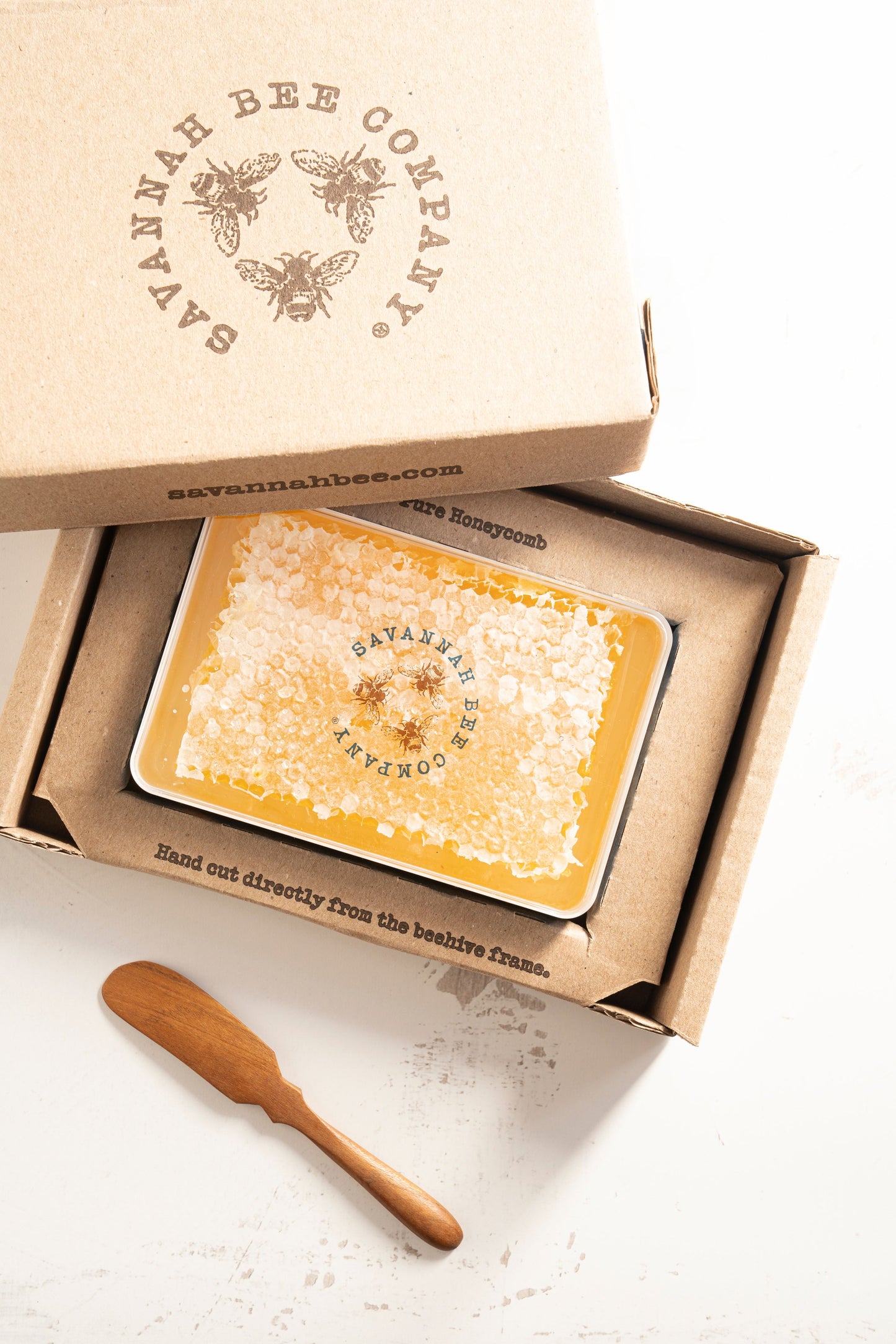 Large honeycomb in a gift box with a teak spoon.