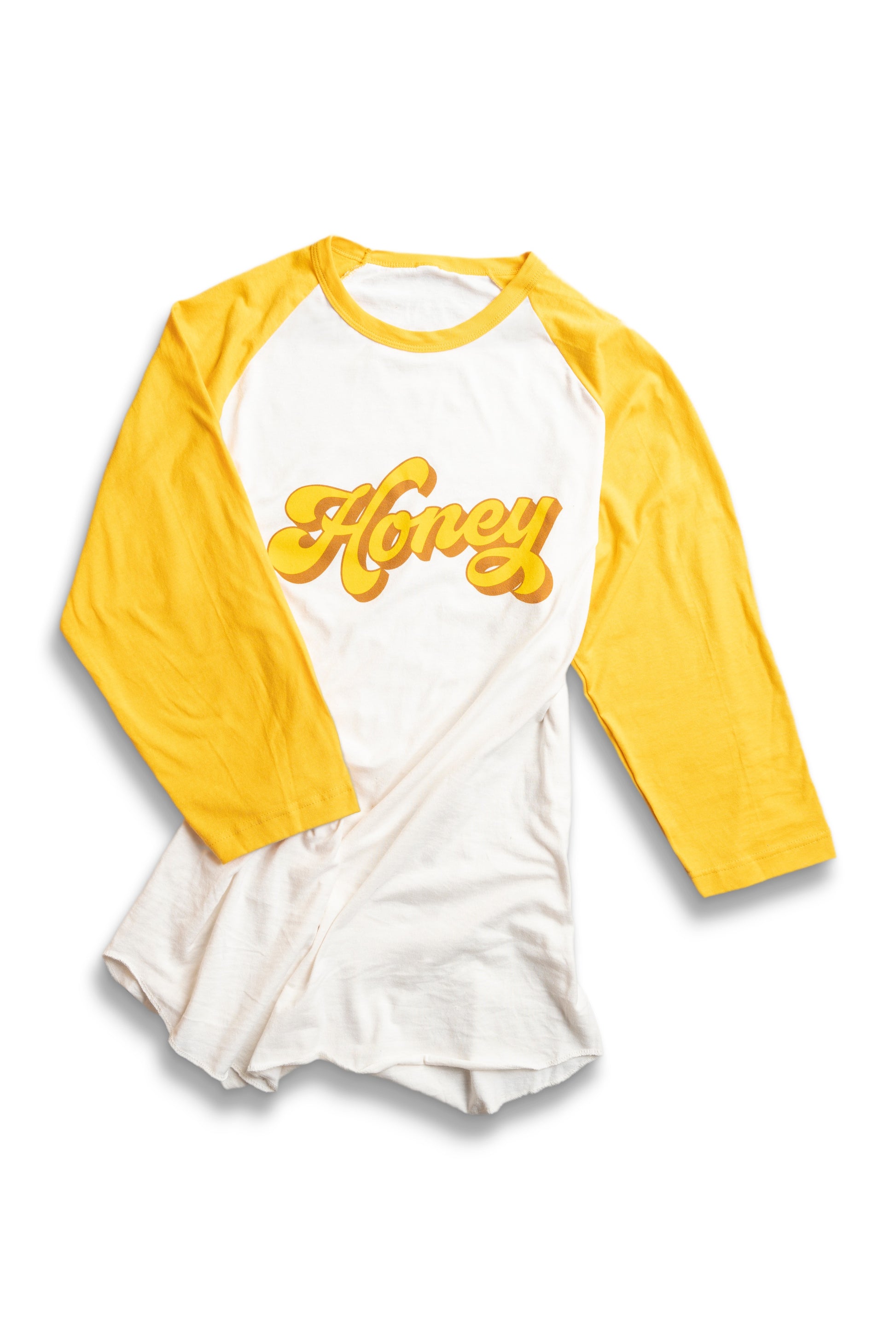 White raglan tee with yellow sleeves with honey in groovy font