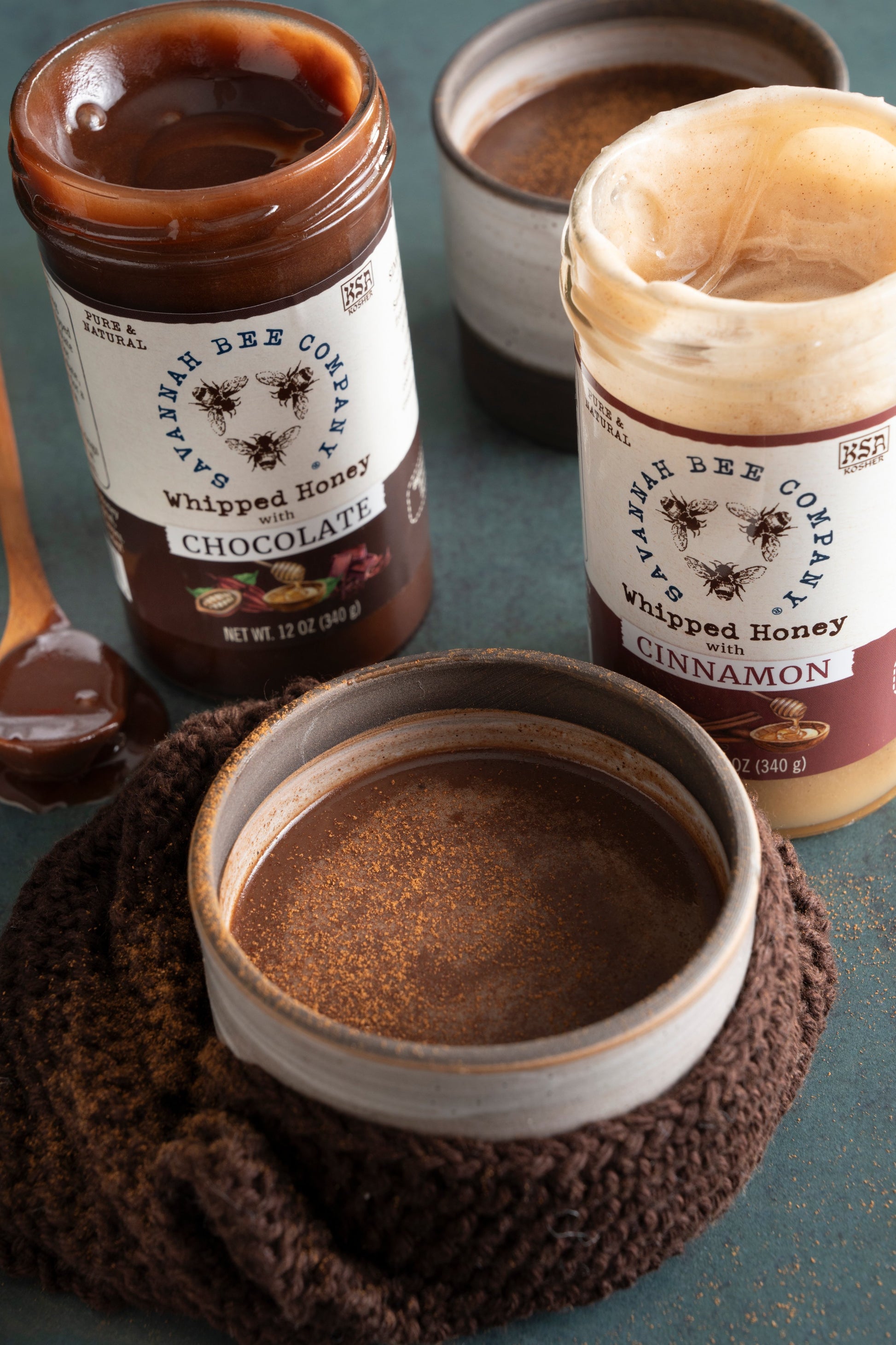 Mexican hot chocolate with a jar of chocolate whipped honey and cinnamon whipped honey.