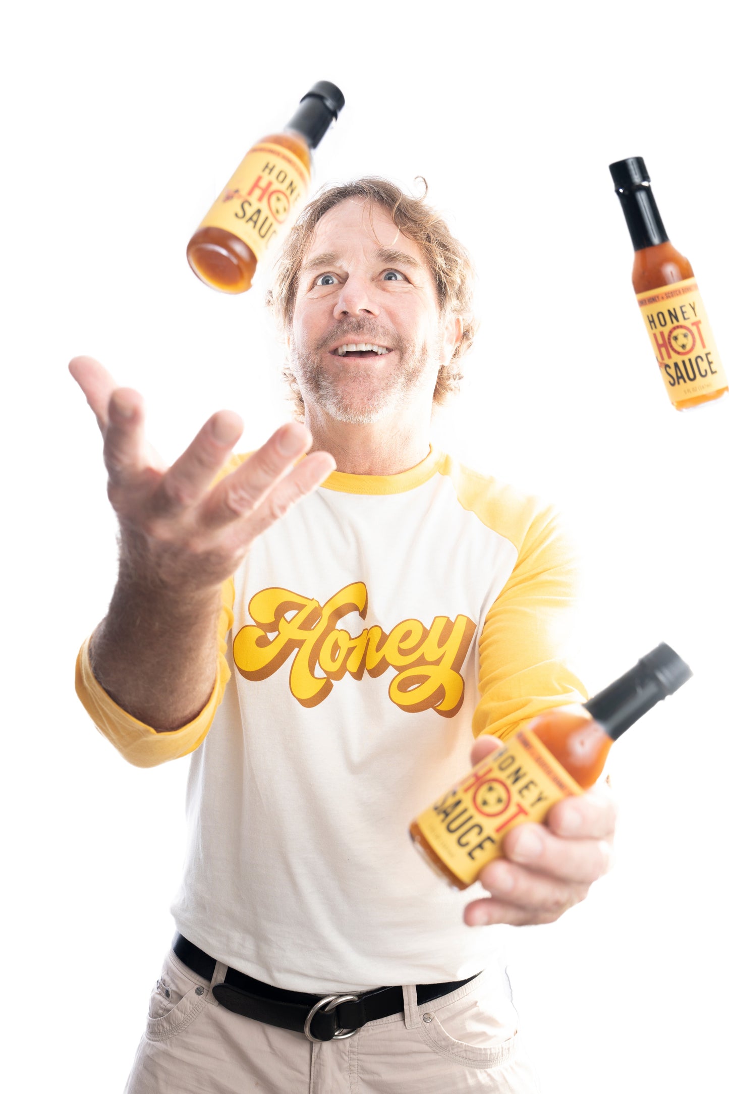 Ted in a honey shirt juggling honey hot sauce wearing a raglan honey t-shirt