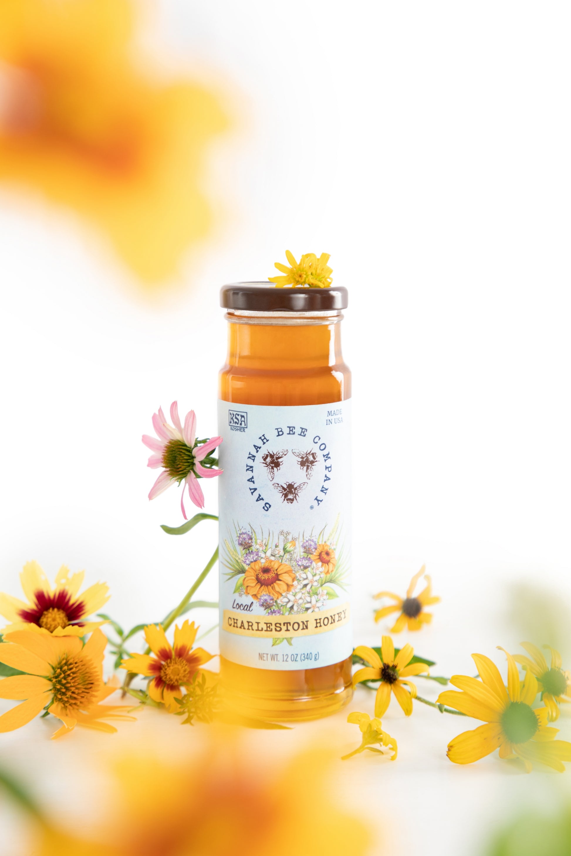 12 ounce Charleston honey surrounded by wildflowers.