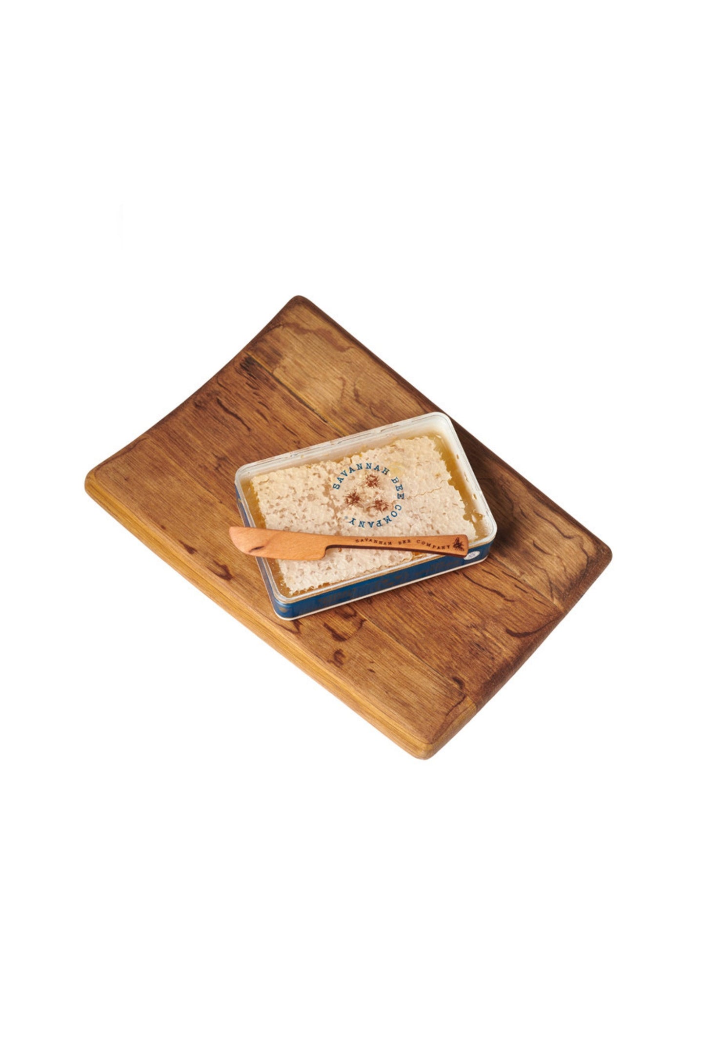 Honeycomb and honey dipper on a beautiful dark wood platter  made from a wine barrel. studio image
