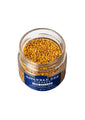 Pure & Natural Savannah Bee Company Bee Pollen 3.53. oz. Lid unscrewed with a ariel shot of bee pollen.